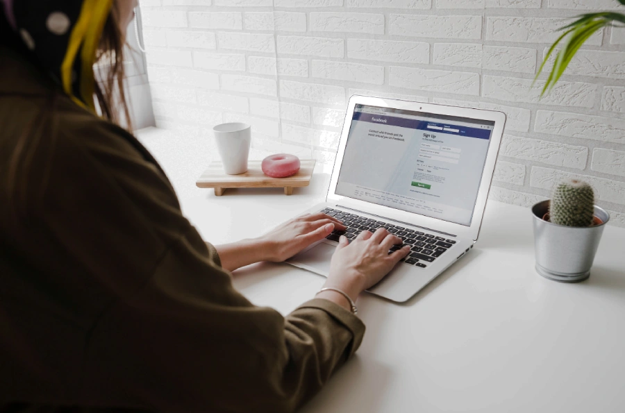 A photo showing a woman working with a laptop.