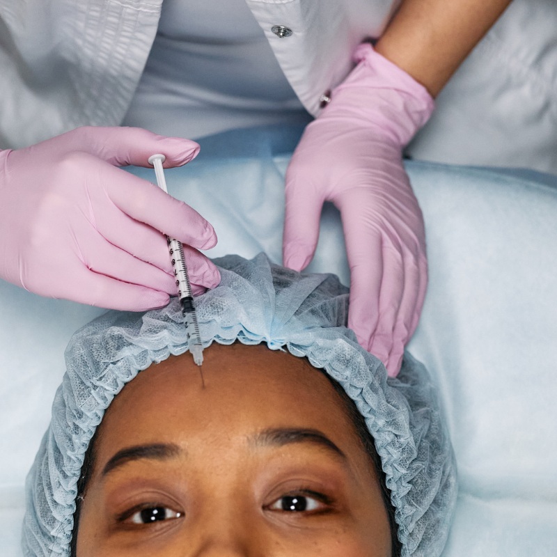 a woman getting botox and filming the treatment