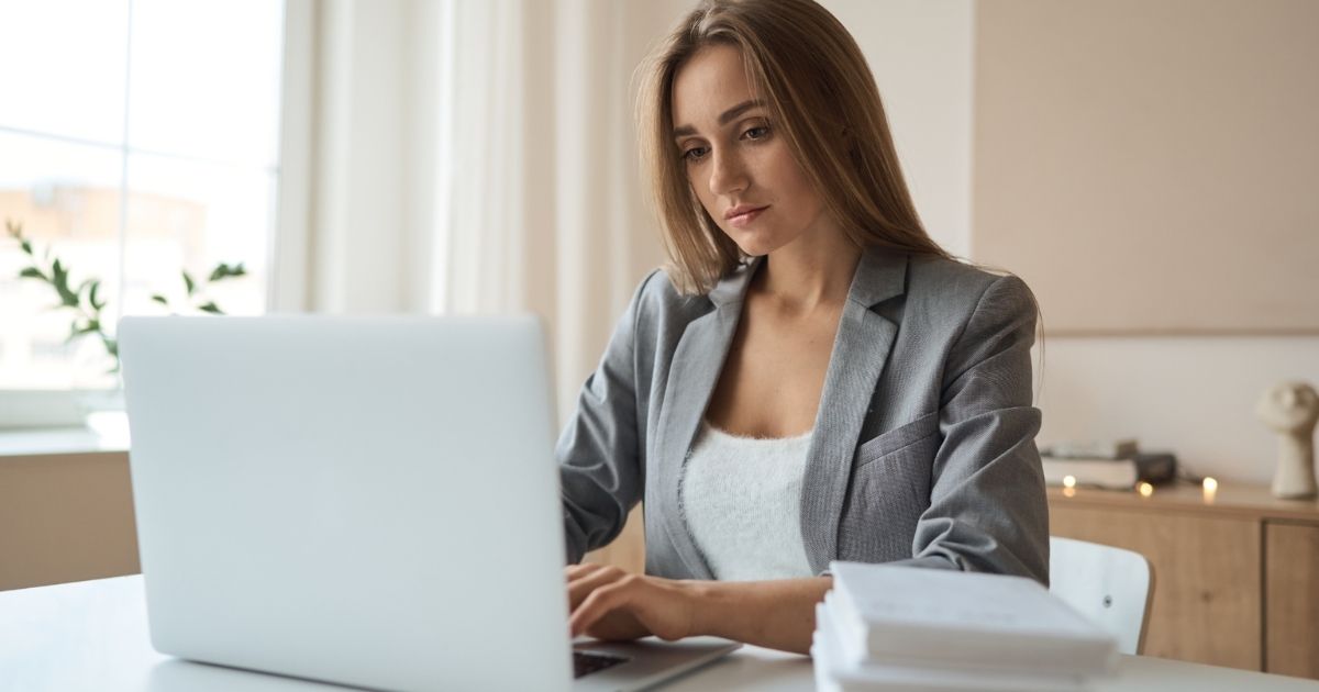 Woman working on a laptop in a bright, modern office.