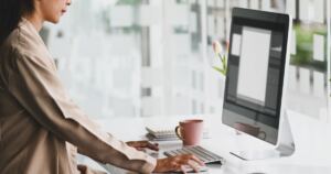 Woman working at a computer in a bright office.