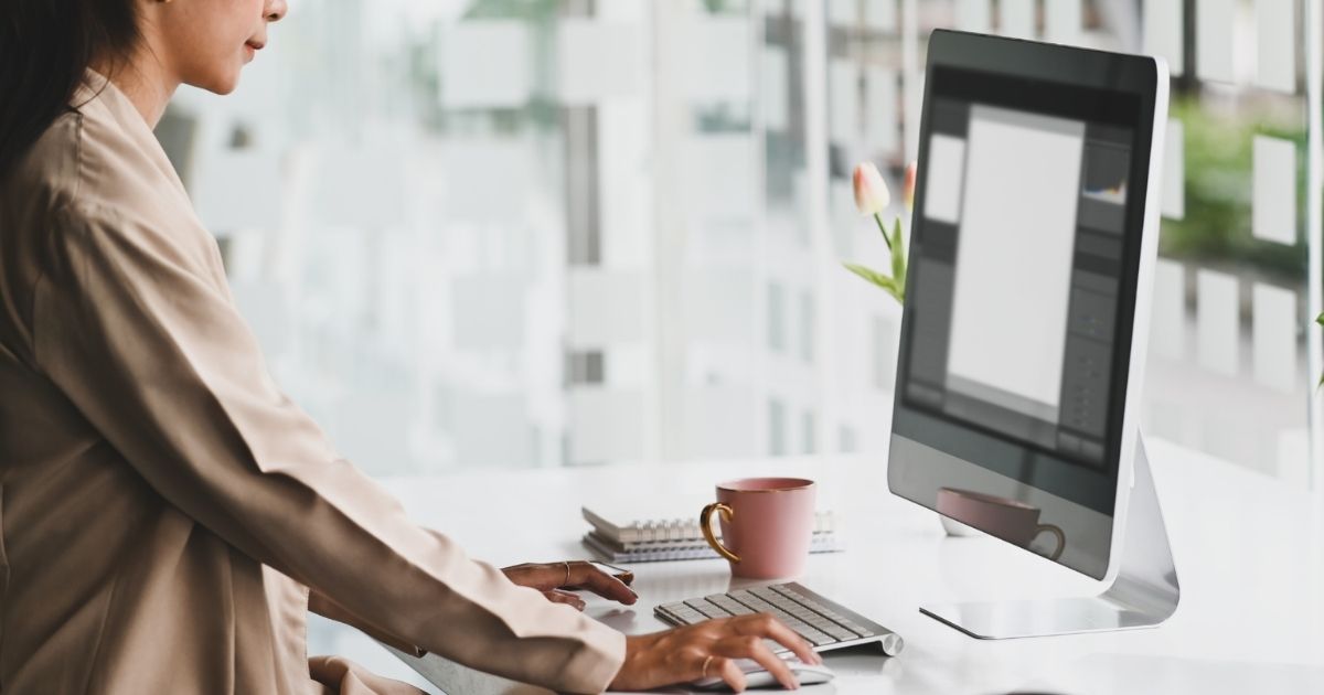 Woman working at a computer in a bright office.