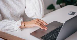 Woman using a laptop at a desk.